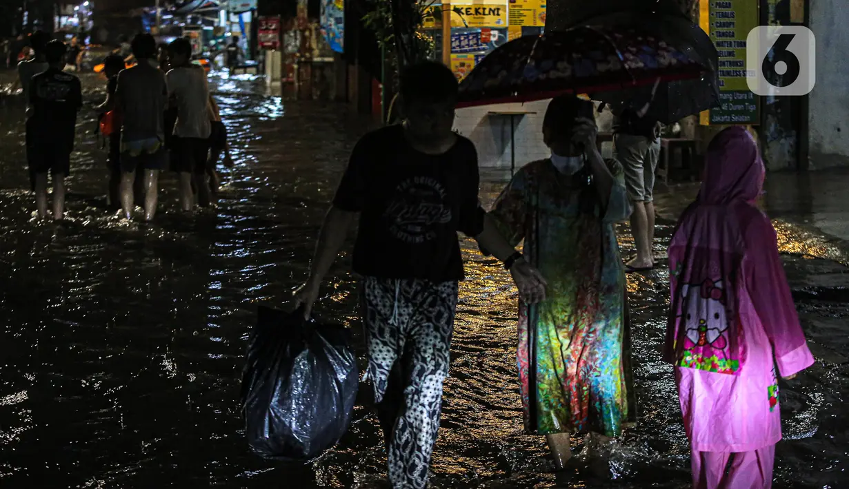 Sejumlah warga melintasi genangan banjir di kawasan Kemang, Jakarta, Selasa (4/10/2022). Jalan Kemang Utara IX tak bisa dilalui oleh kendaraan. Banjir menggenangi kawasan Pasar Kambing dan sejumlah rumah penduduk. (Liputan6.com/Faizal Fanani)