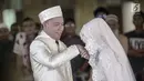 Angel Lelga mencium tangan Vicky Prasetyo saat akad nikah di Mesjid Istiqlal, Jakarta, Jumat (9/2). Kebahagiaan tecermin dari wajah pasangan ini setelah dinyatakan sah sebagai suami istri oleh para saksi. (Liputan6.com/Faizal Fanani)