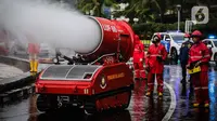 Petugas pemadam kebakaran menyemprotkan cairan disinfektan menggunakan robot LUF 60 di kawasan Bundaran HI, Jakarta, Minggu (22/3/2020). Pemprov DKI Jakarta melakukan penyemprotan fasilitas umum untuk mencegah penyebaran virus corona COVID-19. (Liputan6.com/Faizal Fanani)