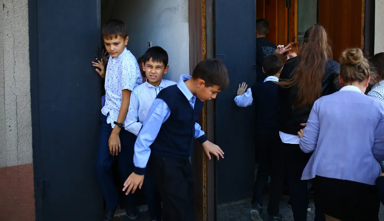 Anak-anak mengambil bagian dalam latihan keamanan di Sekolah Nomor 8, Desa Sartana wilayah timur Ukraina, 2 Oktober 2018. Latihan menghadapi perang dan berlindung dari serangan bom menjadi bagian dari keseharian. (Aleksey FILIPPOV/AFP)