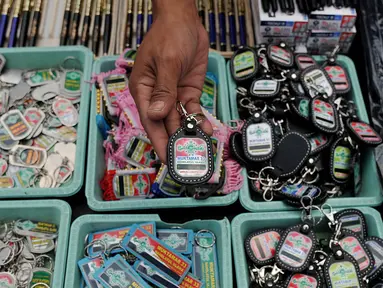 Penjual menunjukkan gantungan kunci berlogo Muktamar ke-33 Nahdlatul Ulama di Jombang, Jawa Timur, Senin (3/8/2015). Pernak-pernik yang dijual yakni kaos, pin, gantungan kunci, dan berbagai produk kerajinan tangan lainnya. (Liputan6.com/Johan Tallo) 