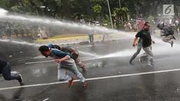 Polisi menyemprotkan water canon ke arah demonstran saat unjuk rasa di depan Gedung Mahkamah Konstitusi, Jakarta, Kamis (13/9). Aksi tersebut merupakan gladi resik simulasi pengamanan Pilpres 2019 yang digelar Polda Metro Jaya. (Liputan6.com/Fery Pradolo)