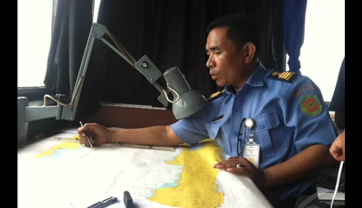 Kapten kapal tim Basarnas mengamati peta titik pencarian pesawat AirAsia QZ8501 di perairan sekitar Belitung Timur, Senin (29/12/2014). (Liputan6.com/Putu Merta Surya Putra)