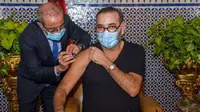 Raja Maroko Mohammed VI menerima suntikan vaksin COVID-19. (Photo credit: Moroccan Royal Palace via AP)