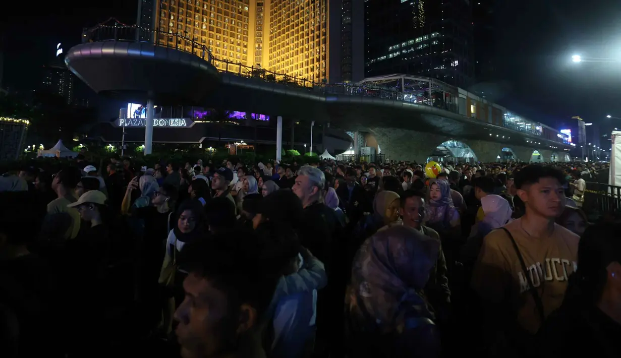 Puluhan ribu warga mulai berdatangan sejak Rabu (31/12/2025) sore hari untuk menanti momen pergantian tahun. Tampak dalam foto, suasana kepadatan warga yang akan menikmati malam pergantian tahun di kawasan Bundaran Hotel Indonesia, Jakarta, Rabu (31/12/2025). (Kapanlagi.com/Budy Santoso)