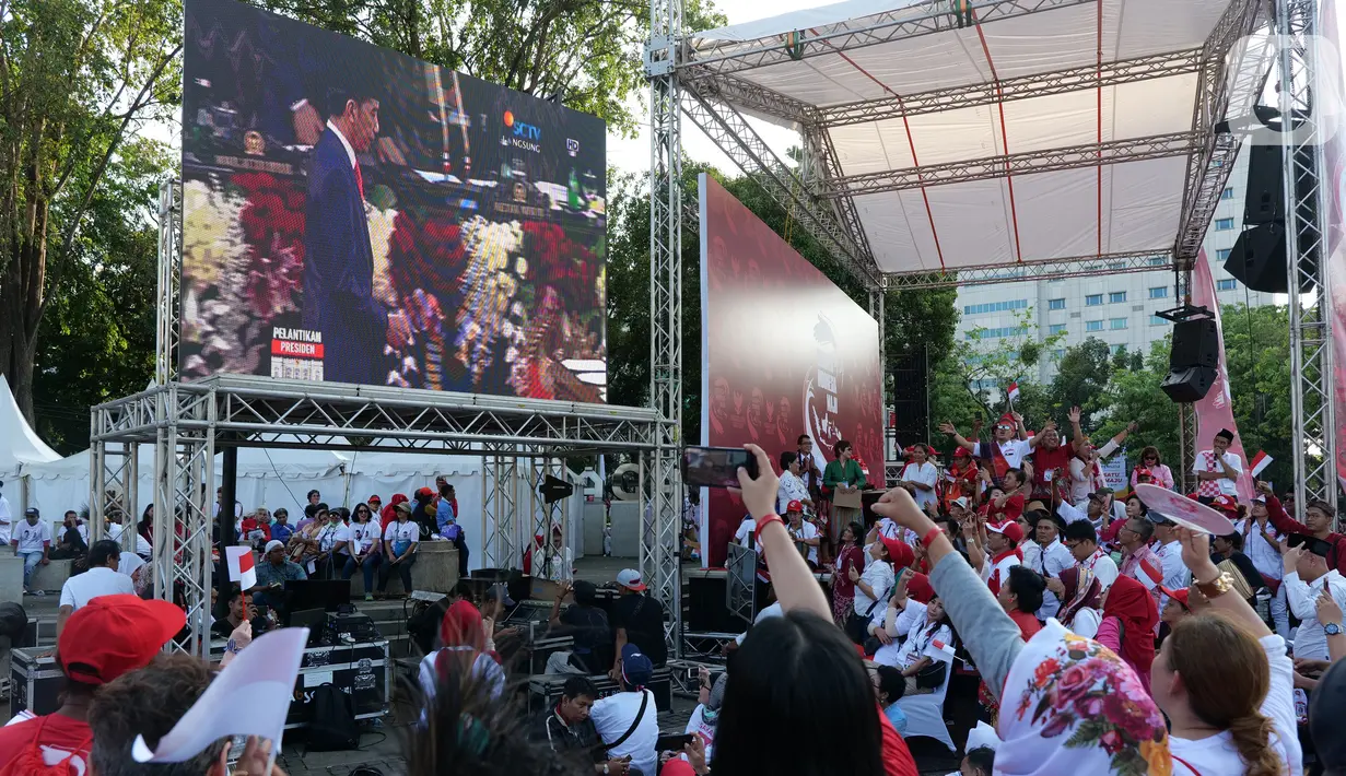 Relawan Joko Widodo-Ma'ruf Amin nonton bareng pelantikan Presiden dan Wakil Presiden di Taman Aspirasi, Jakarta, Minggu (20/10/2019). Jokowi dan Ma'ruf Amin resmi dilantik sebagai Presiden dan Wakil Presiden RI periode 2019-2024. (Liputan6.com/Herman Zakharia)