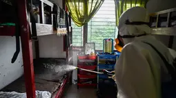 Seorang anggota Badan Penanggulangan Bencana Daerah (BPBD) menyemprotkan disinfektan di sebuah Sekolah Menengah Pertama (SMP) dalam rangka program mitigasi pencegahan penyebaran flu burung di Banda Aceh pada Jumat 31 Oktober 2025. Ini merupakan langkah preventif untuk mencegah potensi penyebaran virus di lingkungan sekolah. (Chaideer MAHYUDDIN/AFP)