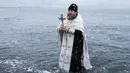 Pastor Rusia Sergius memberkati air laut sebelum mandi Epiphany di Kholmsk, 90 kilometer barat Yuzhno-Sakhalinsk, Pulau Sakhalin di Timur Jauh Rusia, Jumat (19/1). Air yang diberkati dipercaya bisa menyembuhkan penyakit. (AP Photo/Sergey Krasnoukhov)