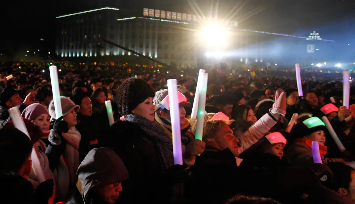 Ekspresi warga Korea Utara saat menyaksikan pertunjukan Tahun Baru 2019 di Kim Il Sung Square, Pyongyang, Selasa (1/1). Grup seni hingga opera memeriahkan perayaan Tahun Baru 2019 di Korea Utara. (AP Photo/Cha Song Ho)