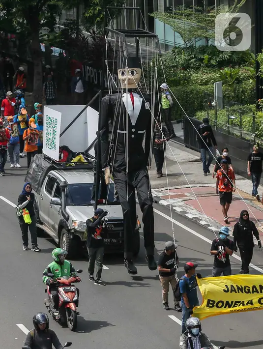 Sebuah boneka kayu raksasa berwajah pinokio pun diarak berkeliling Jakarta. (Liputan6.com/Angga Yuniar)