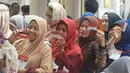 Warga menunjukkan KKS saat Penyaluran Bantuan Sosial PKH dan BPNT di Depok, Jawa Barat, Selasa (12/2). Jumlah bantuan PKH dan BPNT mencapai Rp.70.558.785.000 yang terdiri Rp44.098.560.000 untuk 33.408 Penerima BPNT. (Liputan6.com/Herman Zakharia)