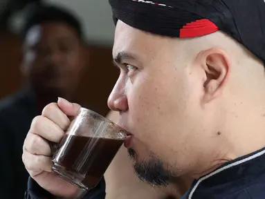 Terdakwa kasus ujaran kebencian, Ahmad Dhani meminum kopi sebelum menjalani sidang lanjutan di PN Jakarta Selatan, Senin (2/7). Sidang tersebut menghadirkan saksi dari jaksa dan saksi meringankan dari Ahmad Dhani. (Liputan6.com/Immanuel Antonius)