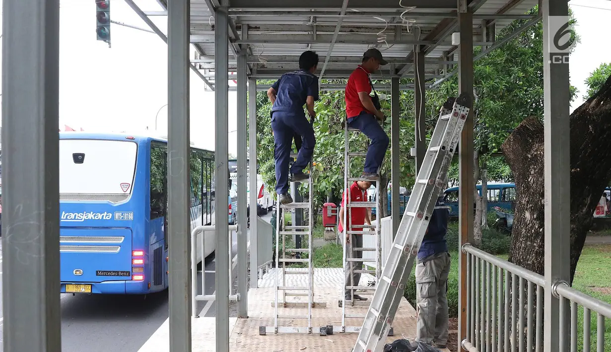 Pekerja menyelesaikan pembuatan halte Transjakarta di kawasan Kampung Rambutan, Jakarta, Jumat (1/3). Pembuatan halte tersebut bertujuan mempermudah warga untuk mengakses bus Transjakarta. (Liputan6.com/Immanuel Antonius)