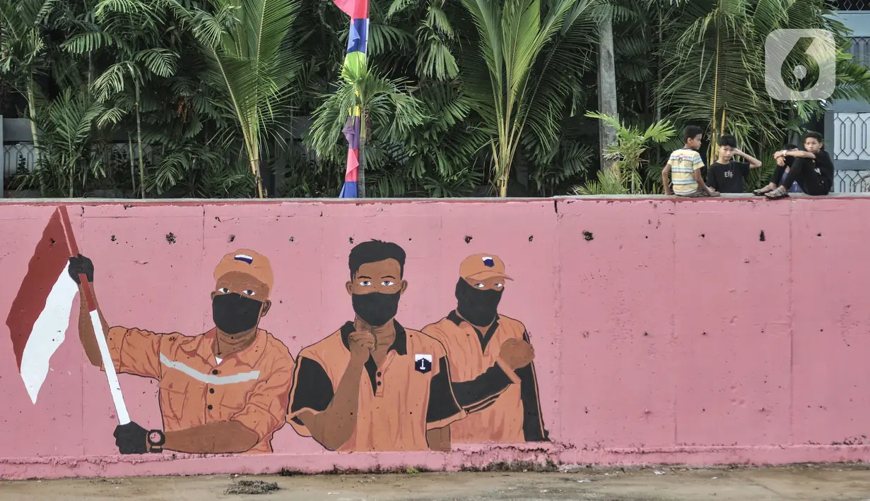 Warga duduk dekat mural bertema HUT ke-75 RI yang menghiasi jalan di Kampung Melayu, Jakarta, Minggu (16/8/2020). Jelang HUT ke-75 RI, mural bernuansa Merah Putih banyak menghiasi jalanan Ibu Kota guna memberi semangat nasionalisme di tengah pandemi COVID-19. (merdeka.com/Iqbal S.Nugroho)