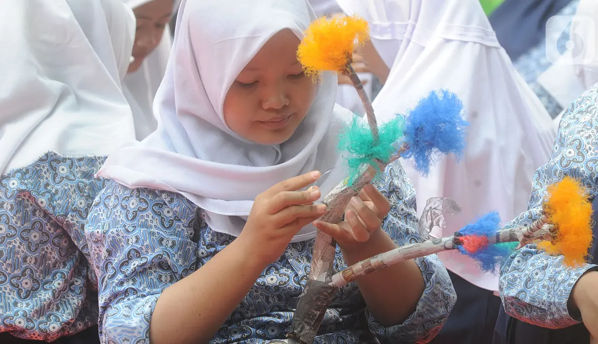 Murid-murid kelas VIII membuat kerajinan tangan dari limbah plastik dan kardus di SMP Negeri 20 Kota Tangerang Selatan, Kamis (10/10/2019). Kegiatan mata pelajaran dalam program Gerakan Sekolah Menyenangkan tersebut sudah berjalan selama 6 bulan. (merdeka.com/Arie Basuki)