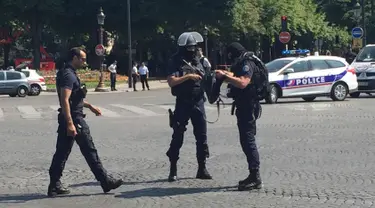 Petugas kepolisian menutup akses jalan Champs Elysees di Paris, Prancis, Senin (19/6). Seorang laki-laki yang diduga terkait dengan ekstrimis menabrakkan mobilnya ke arah mobil van polisi di jalanan ikonik itu. (AP Photo/Bertrand Combaldieu)