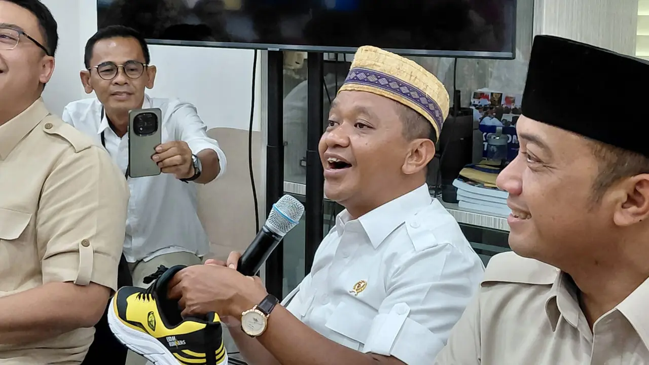 Menteri ESDM Bahlil Lahadalia memamerkan sepatu bewarna kuning yang dipakainya saat mengunjungi Istana Kepresidenan Jakarta, Jumat (24/10/2025) (Liputan6.com/Lizsa Egeham)