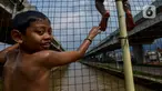 Anak-anak bermain dan berenang di aliran Kalimalang, Jakarta, Sabtu (15/2/2020). Cuaca yang tidak menentu membuat aliran air terkadang menjadi deras sehingga akan membahayakan keselamatan anak-anak saat bermain dan berenang. (merdeka.com/Imam Buhori)