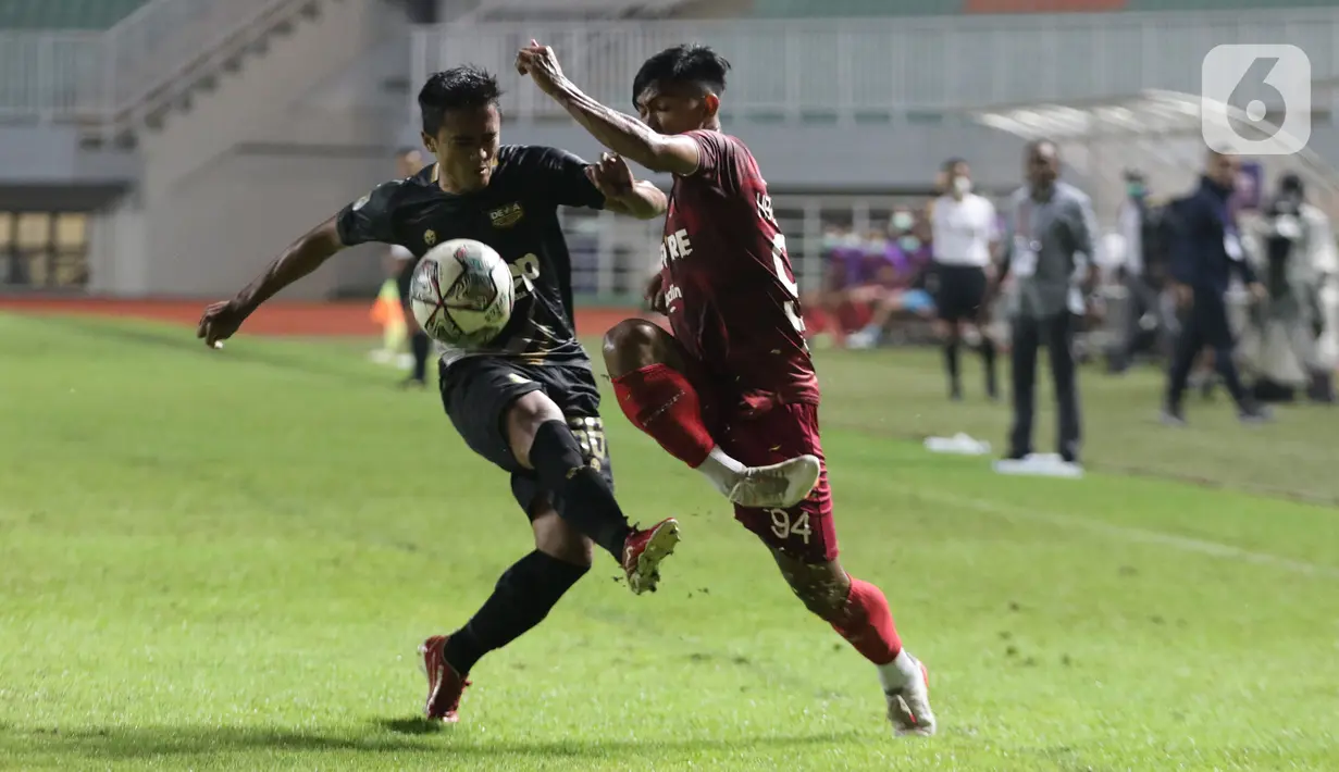 Pemain Persis Solo, Heri Susanto (kanan) berebut bola dengan Gufroni Al Maruf (Martapura Dewa United) pada laga semifinal Liga 2 Indonesia 2021 di Stadion Pakansari, Bogor, Senin (27/12/2021). Persis Solo unggul 2-1 dan memastikan satu tempat promosi ke BRI Liga 1. (Liputan6.com/Helmi Fithriansyah)