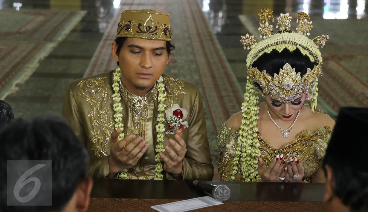 Lucky Hakim dan Tiara Dewi mengaminkan doa seusai akad nikah di Masjid At Tin, Jakarta, Kamis (19/1/). Lucky Hakim dan Tiara Dewi melaksanakan akad nikah hari ini dengan mahar 500 gram logam mulia. (Liputan6.com/Herman Zakharia)