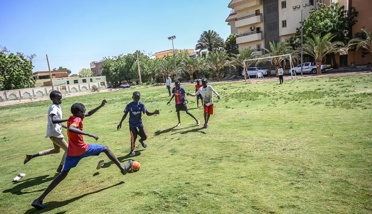 Anak-anak Sudan bermain sepak bola di ibu kota Khartoum (23/4). Khartoum Letaknya di titik di mana Sungai Nil, yang mengalir dari Uganda, bertemu dengan Sungai Nil Biru, yang mengalir dari arah barat di Ethiopia. (AFP Photo/Ozan Kose)