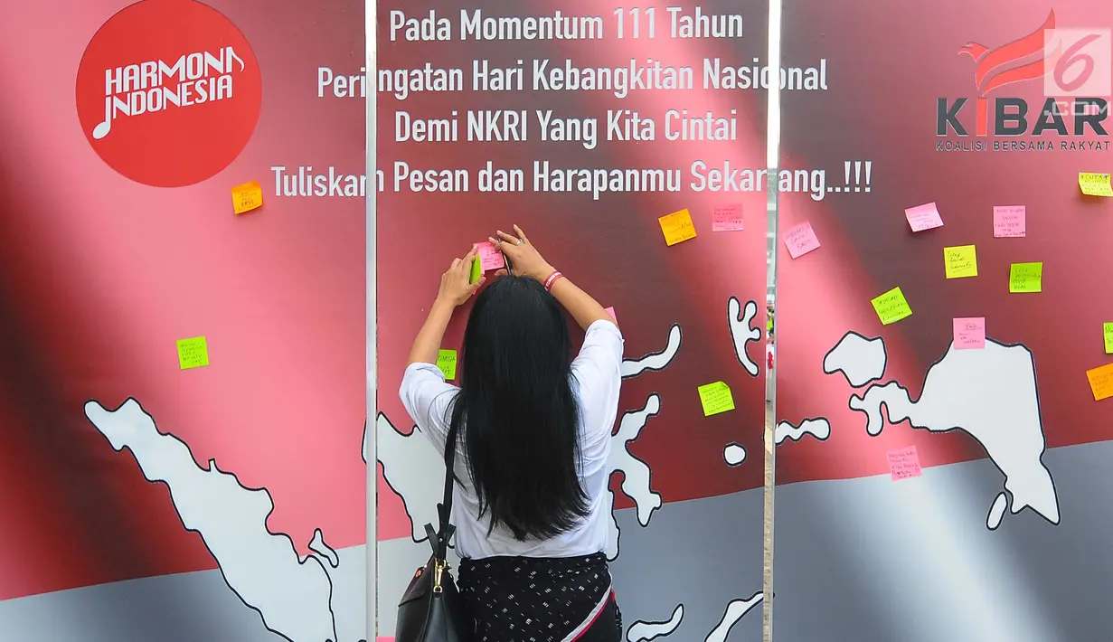 Seorang wanita menempelkan kertas berisi tulisan saat melakukan deklarasi Indonesia Bangkit saat hari kebangktian nasional ke 111 tahun di GBK, Jakarta, Senin (20/5). Tujuan deklarasi ini untuk menyegarkan kembali ingatan dan tekad merawat persatuan Indonesia. (Liputan6.com/Angga Yuniar)