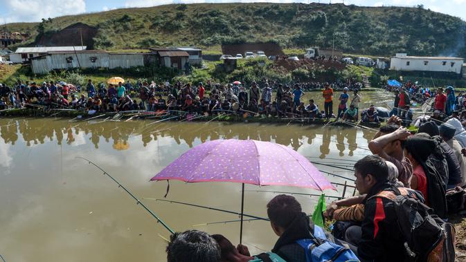 Para peserta pria mengikuti kompetisi memancing di sebuah kolam dekat desa Weilei di Negara Bagian Meghalaya, timur laut India, Sabtu (21/9/2019). Ratusan peserta berpartisipasi dalam kompetisi yang memperebutkan sejumlah hadia tersebut. (DIPTENDU DUTTA / AFP)