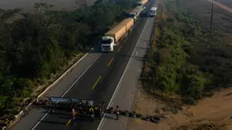 Masyarakat suku Kayapo saat memblokir jalan raya utama Trans-Amazonian dengan melakukan barikade menggunakan ban bekas di Novo Progresso di Negara Bagian Para, Brasil (17/8/2020). (AFP Photo/Carl De  Souza)