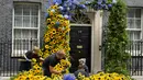 Toko bunga menyiapkan pintu masuk ke 10 Downing Street dengan bunga matahari yang merupakan bunga nasional Ukraina, sehari menjelang Hari Kemerdekaan Ukraina, di London, Selasa (23/8/2022). Perdana Menteri Boris Johnson menunjukkan solidaritas Inggris dengan Ukraina dengan bunga matahari untuk memperingati hari kemerdekaan negara Eropa timur itu. (AP Photo/Frank Augstein)