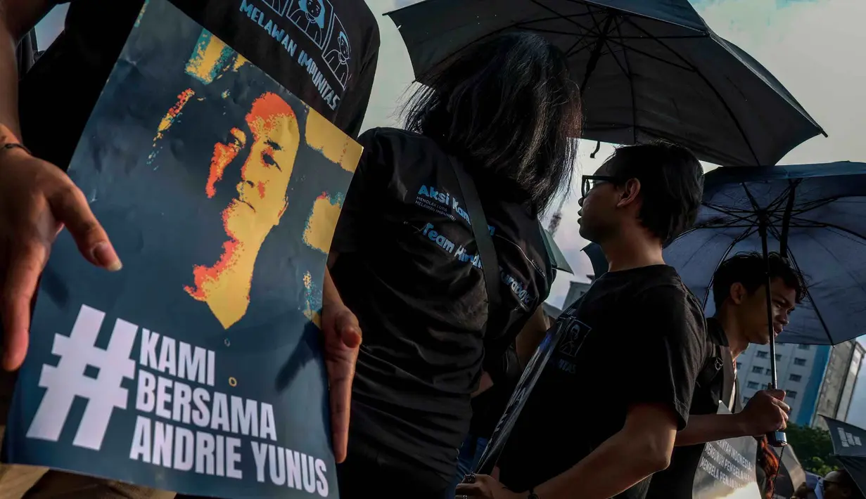 Dalam Aksi Kamisan ke-906, para aktivis mendesak aparat penegak hukum serius menuntaskan kasus penyiraman air keras terhadap Wakil Koordinator KontraS, Andrie Yunus. Tampak dalam foto, para aktivis memegang payung hitam dan poster selama Aksi Kamisan di depan Istana Kepresidenan, Jakarta, Kamis 30 April 2026. (BAY ISMOYO/AFP)