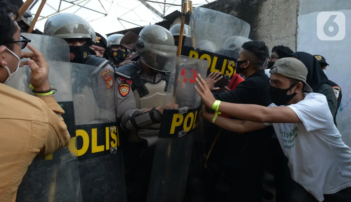 Polisi terlibat saling dorong dengan warga saat melakukan eksekusi lahan rumah warga Kelurahan Pulogebang RT 20 RW 06 (dahulu RT 08/RW 06) di Jakarta, Selasa (8/6/2021). Eksekusi lahan tersebut berakhir ricuh. (merdeka.com/Imam Buhori)