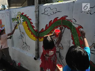Sejumlah anak melukis mural pada dinding areal gang sempit saat kegiatan kick off Kampung Mural di Pulo Gelis, Bogor, Minggu (18/3). Kegiatan membuat mural dengan berbagai tema ini diikuti sejumlah komunitas dan warga setempat. (Merdeka.com/Arie Basuki)
