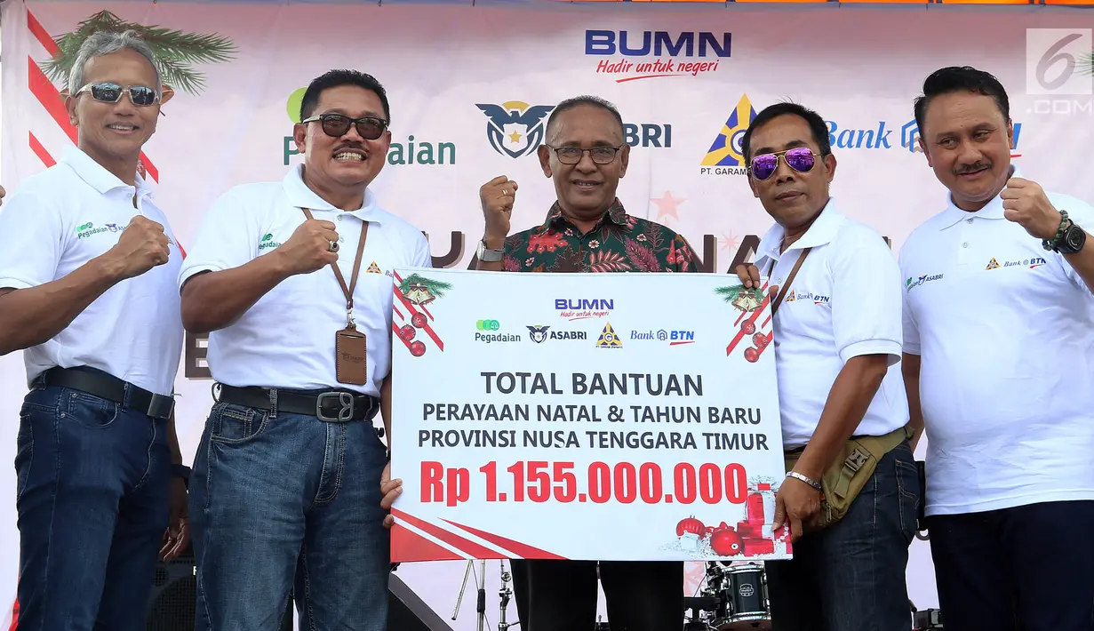 Empat direksi BUMN memberi bantuan kepada Asisten III Sekda Sumba Timur Ishak Raga Koda saat Natal bersama dan bantuan CSR Sinergi BUMN di Kota Waingapu, Sumba Timur, Sabtu (15/12). BUMN bersinergi meningkatkan kehidupan sosial. (Liputan6.com/JohanTallo)