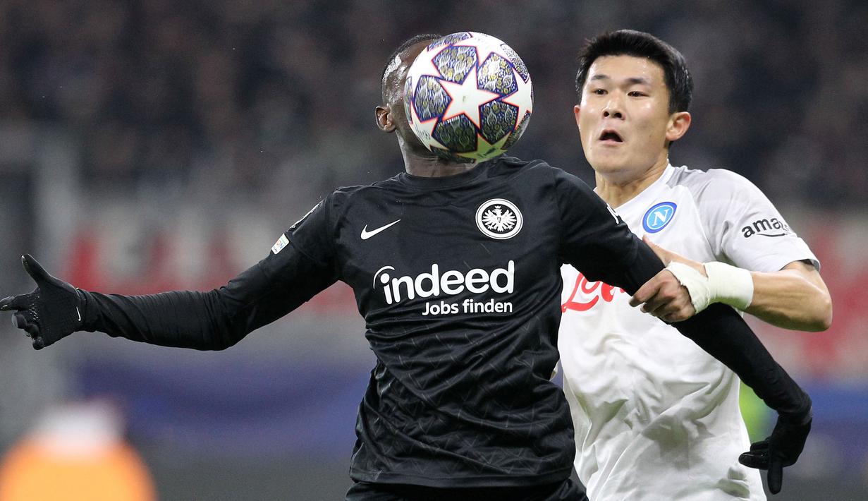 <p>Pemain Eintracht Frankfurt, Randal Kolo Muani (kiri) berebut bola dengan pemain Napoli, Min-jae Kim pada laga leg pertama 16 besar Liga Champions 2022/2023 yang berlangsung di Deutsche Bank Park, Rabu (22/2/2023) WIB. (AFP/Daniel Roland)</p>