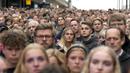 Orang-orang berkumpul untuk mengenang para korban penembakan di pintu masuk pusat perbelanjaan Field di Kopenhagen, Denmark, 5 Juli 2022. Pihak berwenang pada hari Senin mengajukan dakwaan awal pembunuhan dan percobaan pembunuhan terhadap seorang pria Denmark berusia 22 tahun. (AP Photo/Sergei Grits)