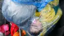 Anak pengungsi tidur dalam perjalanan dari Slovenia melintasi perbatasan menuju Trnovec, Kroasia, Senin (19/10). Ribuan orang terjebak cuaca dingin di desa perbatasan Serbia Berkasovo setelah Kroasia membendung para pendatang. (REUTERS/Antonio Bronic)