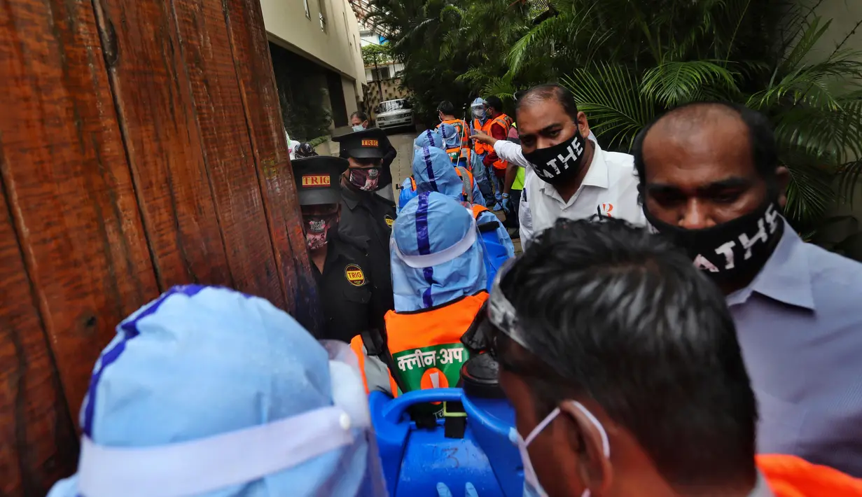 Pekerja otoritas sipil tiba di kediaman bintang Bollywood Amitabh Bachchan di Mumbai (12/7/2020). Bachchan dan putranya Abhishek Bachchan terpapar virus Corona Covid-19. ).  (AP Photo/Rafiq Maqbool)