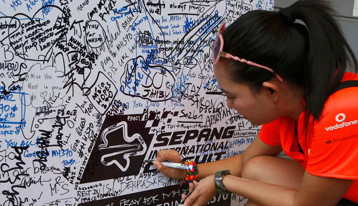 Di salah satu sudut Sirkuit Sepang Malaysia, warga terus membubuhkan tanda tangan sebagai bentuk dukacita atas tragedi MAS MH-370 (REUTERS/Edgar Su)