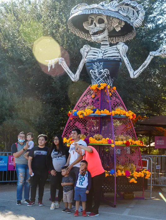 Sejumlah orang berfoto di depan berbagai dekorasi saat perayaan Hari Orang Mati di San Antonio, Texas, AS (2/11/2020). Hari Orang Mati adalah hari raya Meksiko yang melibatkan keluarga dan teman berkumpul untuk berdoa serta mengenang teman dan anggota keluarga yang telah meninggal. (Xinhua/Lie Ma)