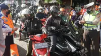 Aparat gabungan dari Polrestabes Bandung, TNI, Satpol PP, dan Dinas Perhubungan, memperketat pemeriksaan kendaraan di pintu masuk Kota Bandung tepatnya Bundaran Cibiru, untuk mencegah penyebaran virus Corona (Covid-19). (Liputan6.com/Huyogo Simbolon)
