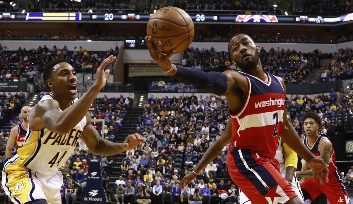 Aksi pemain Washington Wizards, John Wall (2) mengontrol bola saat berduel dengan pemain Indiana Pacers, Jeff Teague (kiri) pada laga NBA basketball game di Bankers Life Fieldhouse, Indianapolis, (19/12/2016). (AP/R Brent Smith)