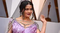 Aktris Salma Hayek berpose untuk fotografer setibanya di karpet merah ajang Piala Oscar 2018 atau Academy Award ke-90 di Dolby Theatre, Los Angeles, Minggu (4/3). Penampilan Salma Hayek di karpet merah terlihat super glamor. (Jordan Strauss/Invision/AP)