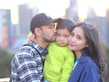 Pemilik nama lengkap Rafathar Malik Ahmad tengah diapit mesra oleh kedua orang tuanya, Raffi Ahmad dan Nagita Slavina. Mereka bertiga menikmati suasana sore hari di Melbourne, Australia. (Liputan6.com/IG/@raffinagita1717)