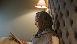 Wanita muslim membaca buku di kasur (Pexels)