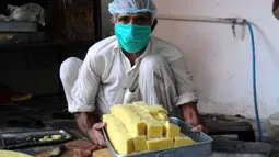Seorang pria membuat penganan manis tradisional di hari raya Idul Fitri di Peshawar, Pakistan barat laut, pada 25 Mei 2020. Warga Pakistan memiliki tradisi memakan penganan manis saat merayakan Idul Fitri, yang menandai akhir bulan puasa Ramadan. (Xinhua/Saeed Ahmad)