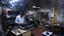 Teknisi mesin tik, Anand Savarkar memperbaiki mesin tik di bengkelnya di Mumbai, India (6/7). Mesin tik di India kini mulai ditinggalkan, karena terasa sudah ketinggalan zaman di era komputer dan Internet. (AFP Photo/Indranil Mukherjee)