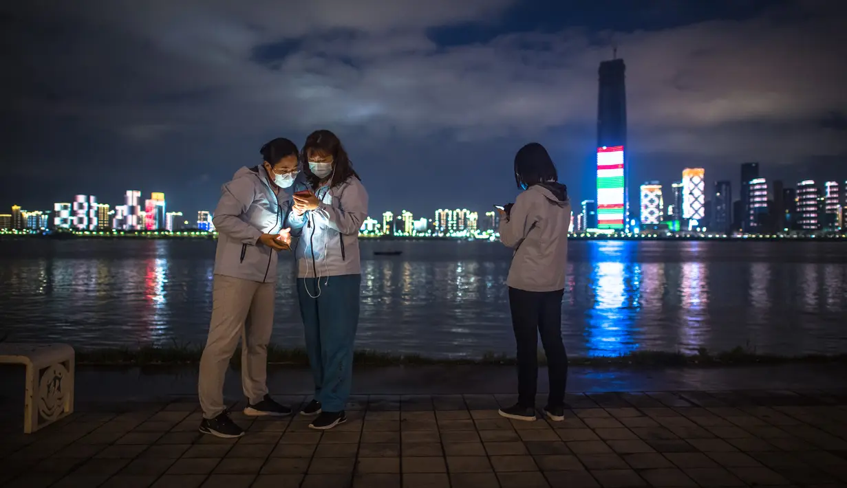 Para anggota tim medis Beijing menikmati panorama sungai di sebuah lokasi di Taman Jiangtan Hankou di Wuhan, Provinsi Hubei, China tengah, pada 26 Maret 2020. Seiring meredanya wabah virus corona (Covid-19), kehidupan di Wuhan berangsur-angsur kembali normal. (Xinhua/Xiao Yijiu)