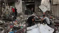 Warga Palestina mencari puing-puing bangunan untuk mencari barang-barang yang masih bisa diselamatkan setelah serangan udara Israel di Kota Gaza pada tanggal 11 Oktober 2023. (Mohammed ABED/AFP)