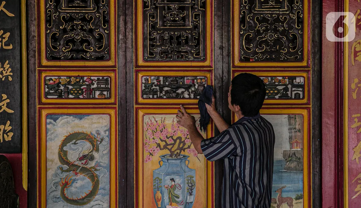 Pekerja membersihkan pintu di lingkungan Vihara Tanda Bhakti di kawasan Petak Sembilan, Glodok, Jakarta, Rabu (3/2/2021). Bersih-bersih Rumah Ibadah dilakukan untuk menyambut Hari Raya Imlek yang jatuh pada 12 Februari 2021. (Liputan6.com/Faizal Fanani)
