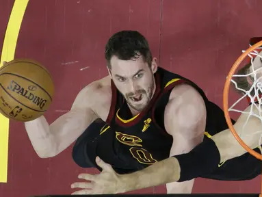 Aksi pemain Cleveland, Kevin Love (kiri) melakukan lay up saat diadang pemain Raptors, Jonas Valanciunas pada gim keempat semifinal Wilayah Timur NBA playoff di Quicken Loans Arena, Cleveland, (7/5/2018). (AP/Tony Dejak)